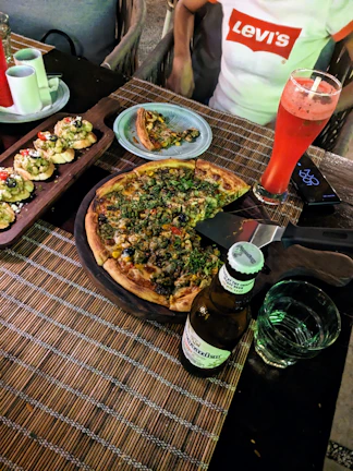 A cozy table setting with a variety of pizzas and a cold guaraná 1.5L bottle ready to enjoy.