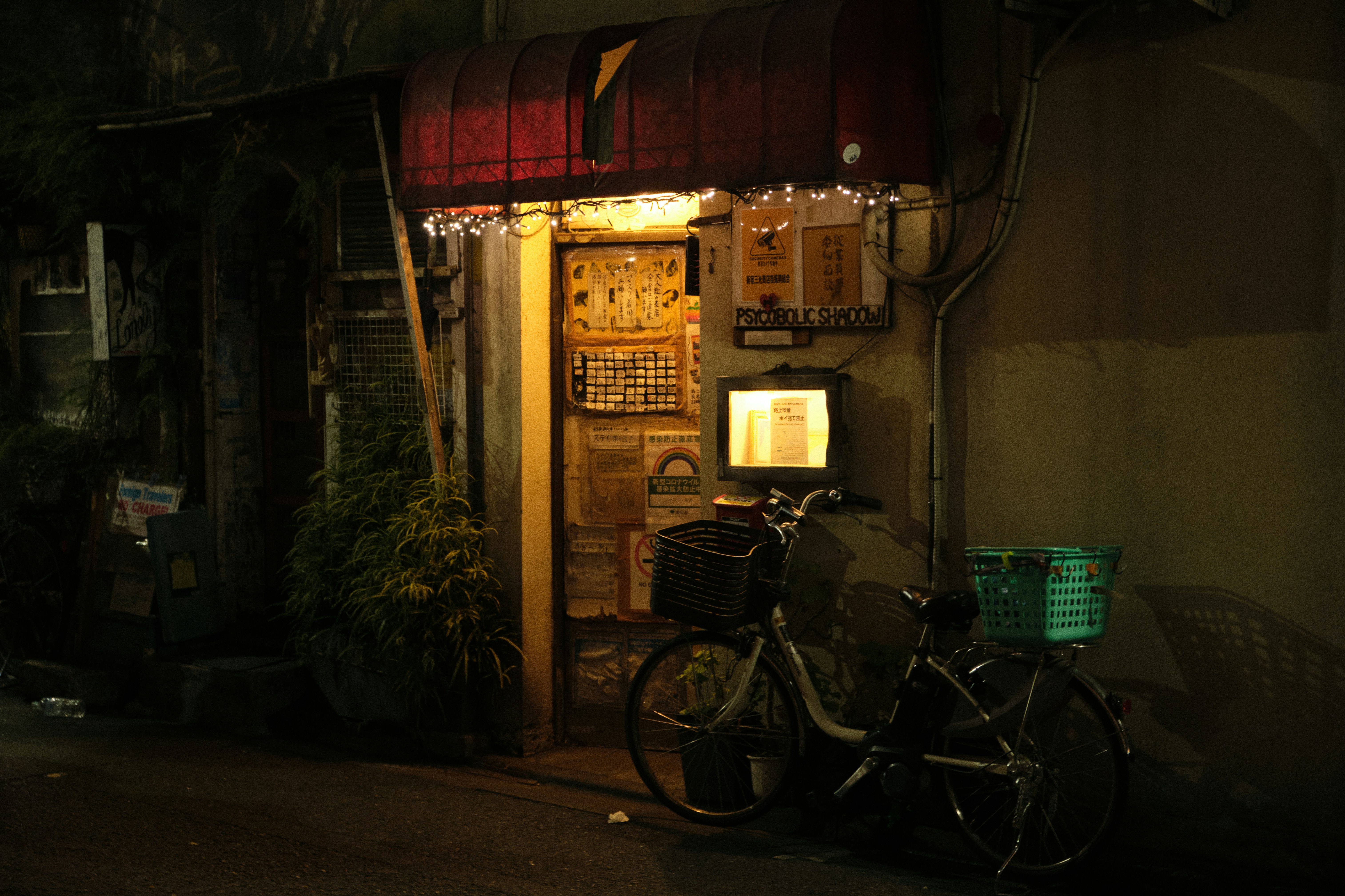 Narrow alleyway in Shinjuku Golden Gai or Omoide Yokocho at night, lanterns, small bar fronts