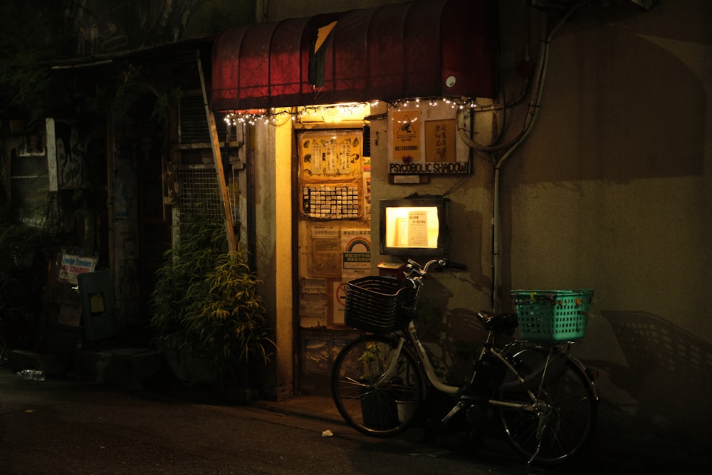 a bicycle parked outside of a building at night