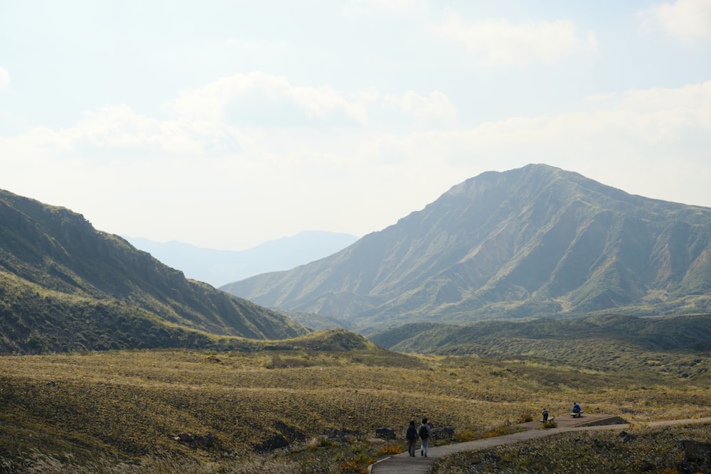 a group of people walking down a dirt road