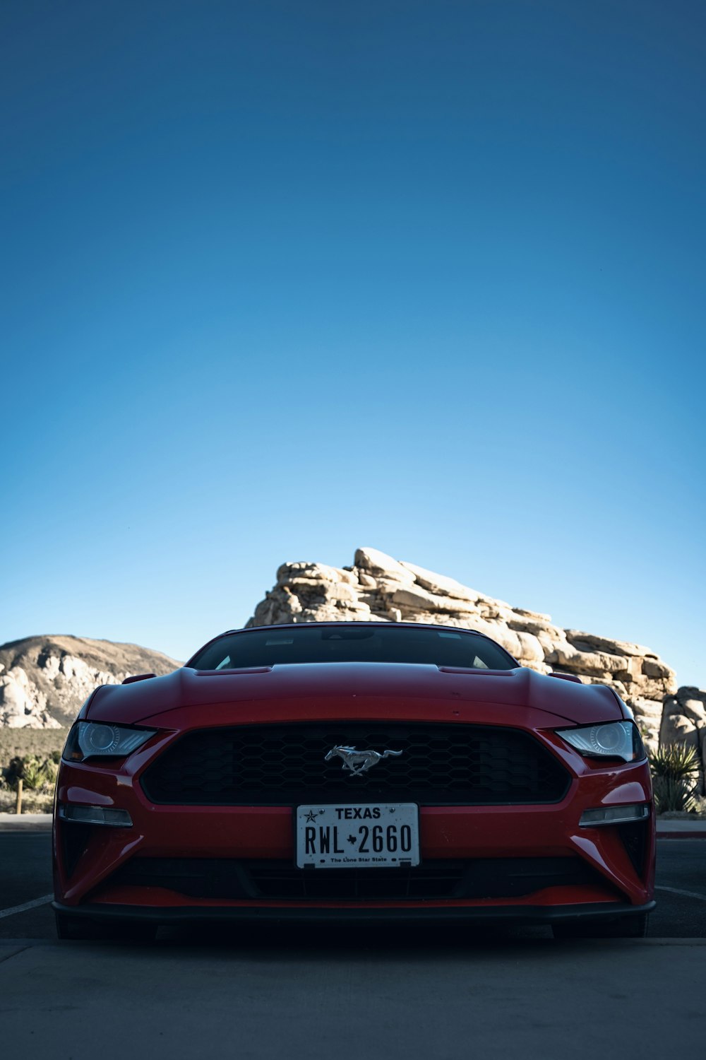 a red mustang parked in a parking lot