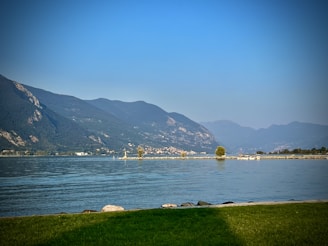 A scenic view of a boat on a calm lake with mountains in the background.