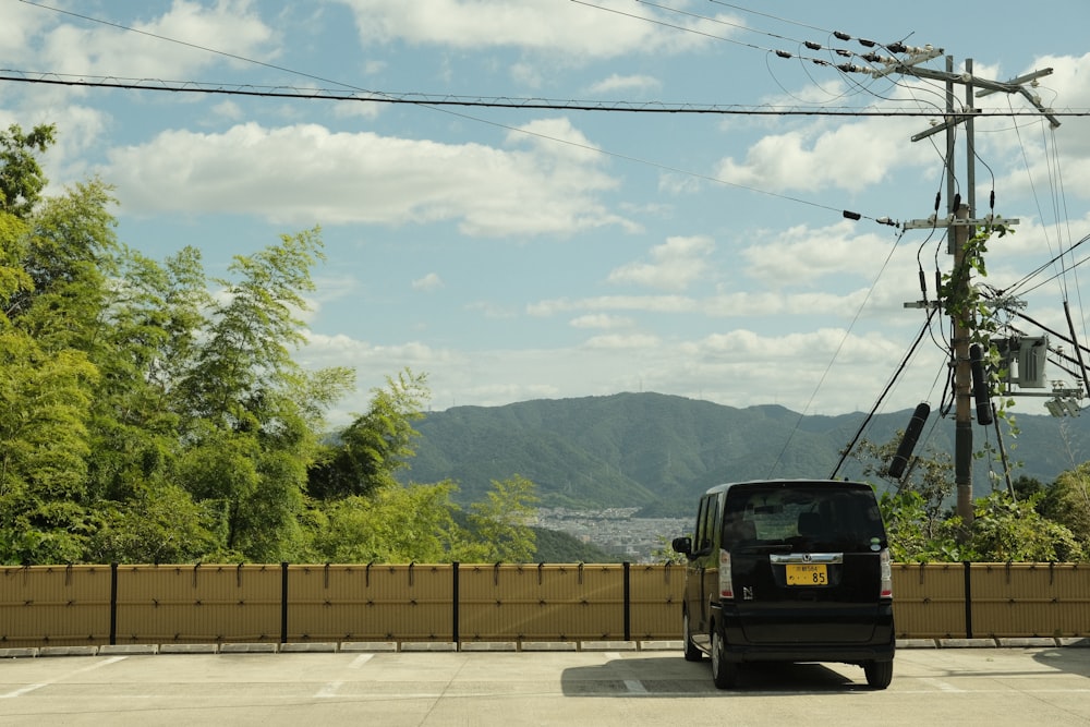 a black truck driving down a road next to power lines