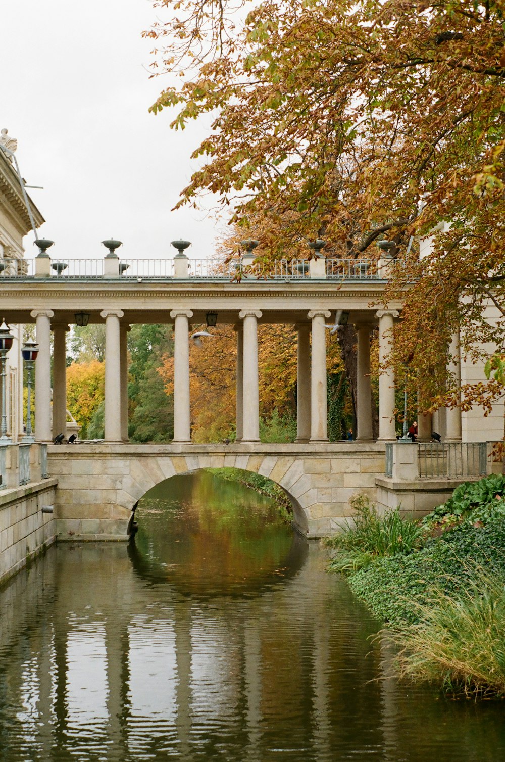 a bridge over a body of water with a building in the background