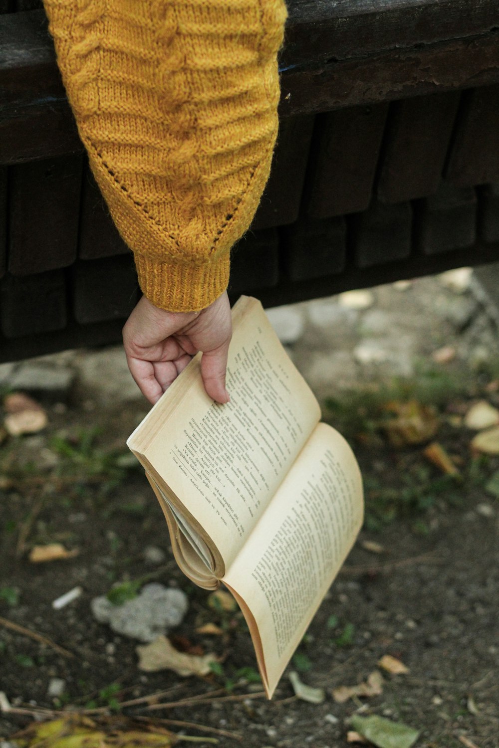 a person holding an open book in their hand