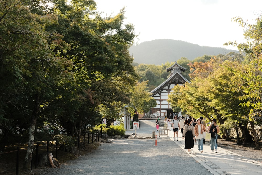 a group of people walking down a path in a park