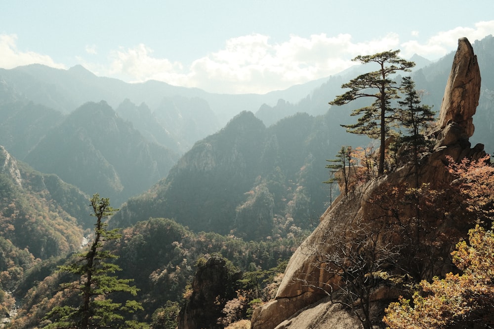 a view of a mountain range with trees and mountains in the background