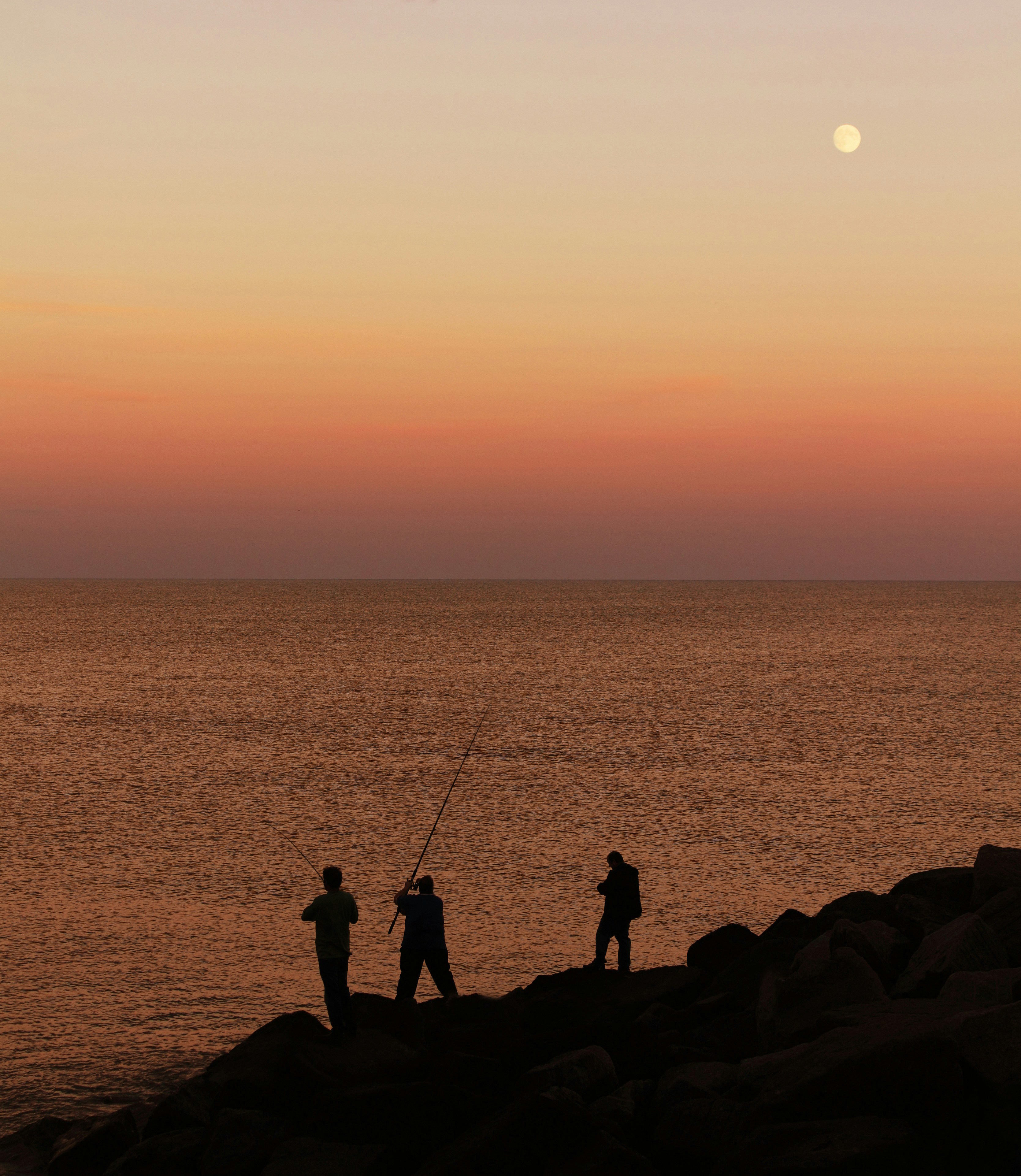 岩だらけのビーチの上に立つ2人の男性