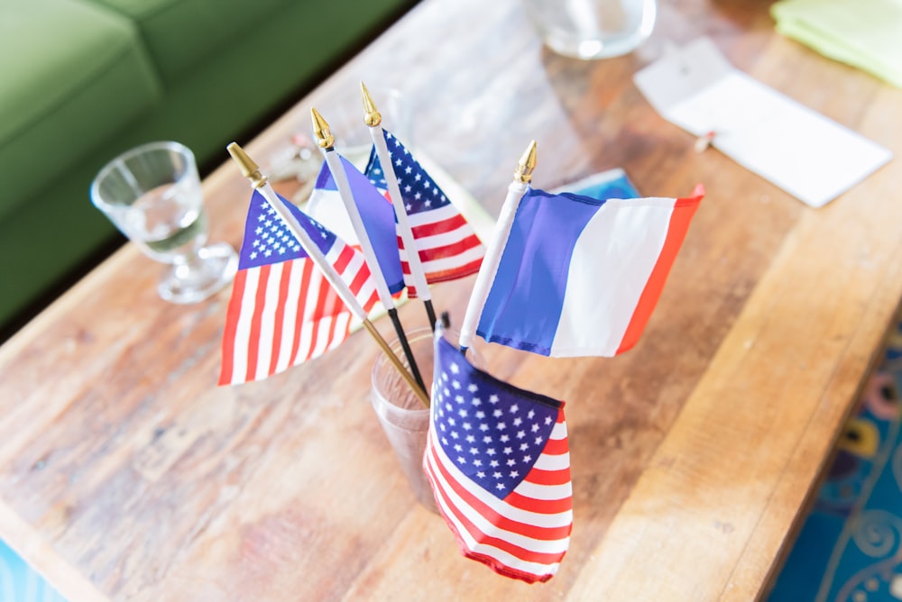 a wooden table topped with american and french flags