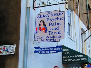 a sign on the side of a building that says aura shop psychic palm and tar