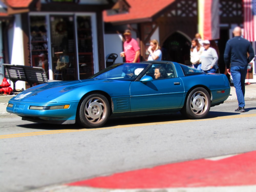 a blue sports car parked on the side of the road