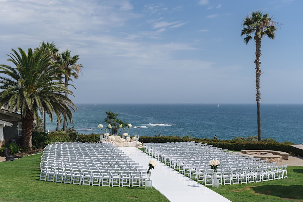 a wedding set up on a lawn overlooking the ocean