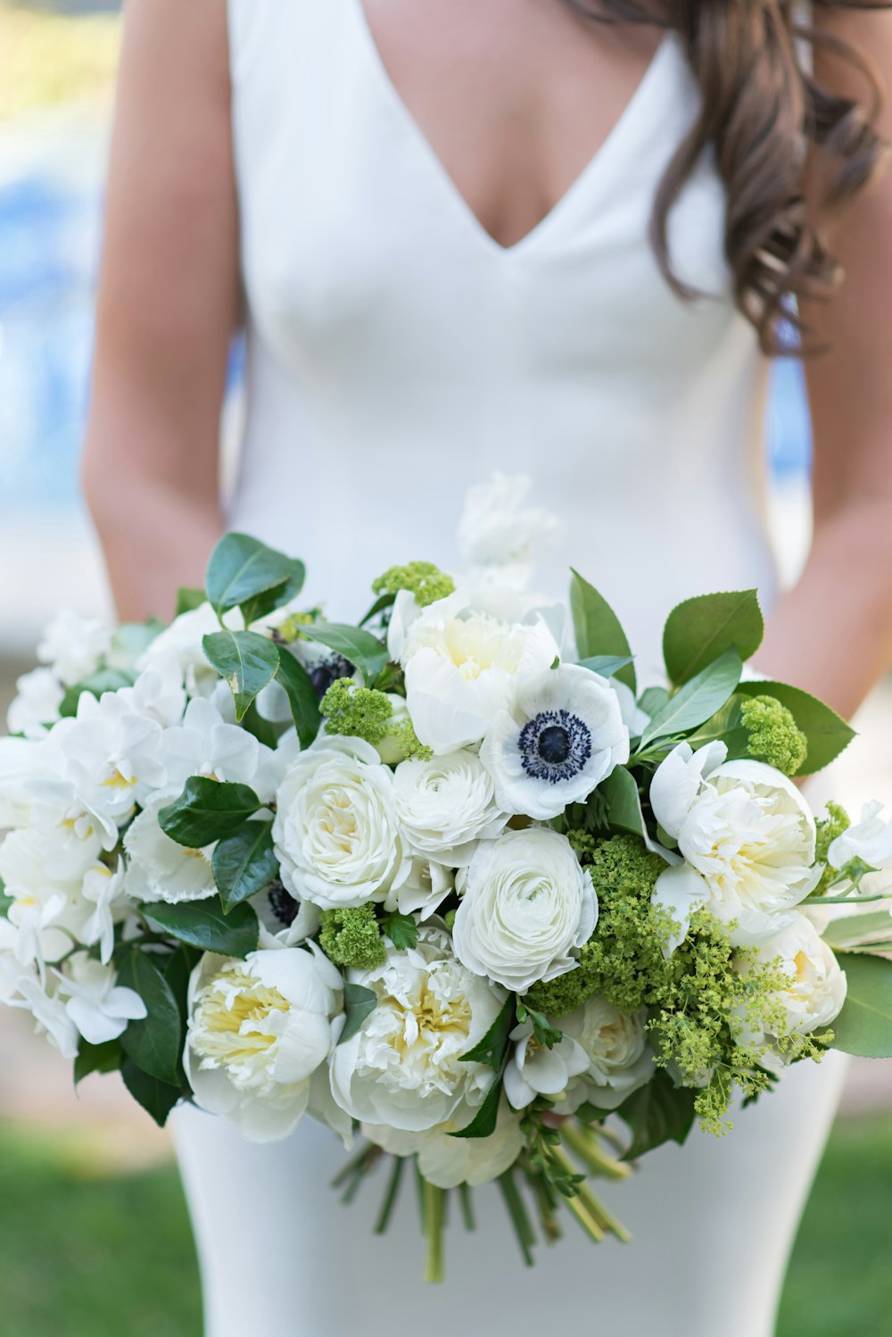 a bride holding a bouquet of white flowers