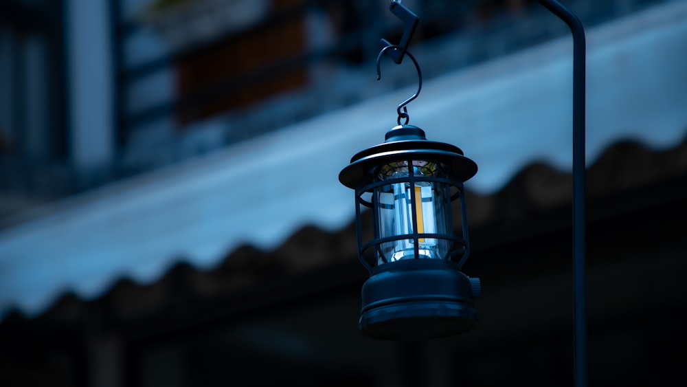 a blue light hanging from a pole in front of a building