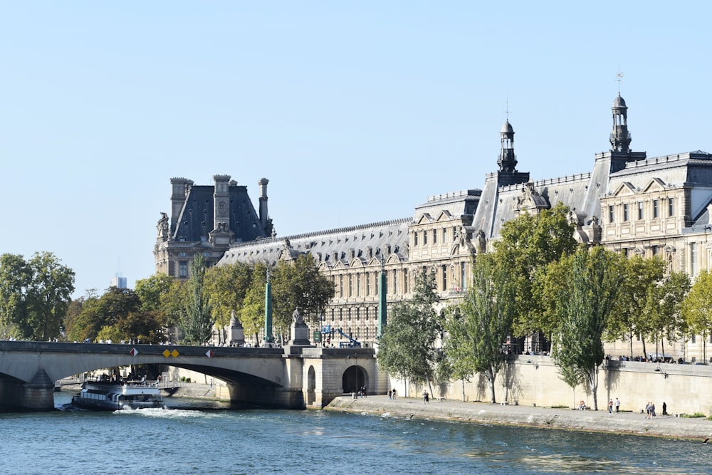 a boat traveling down a river next to a tall building