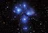 Close-up of a twinkling star cluster softly illuminating a serene, cosmic blue background.