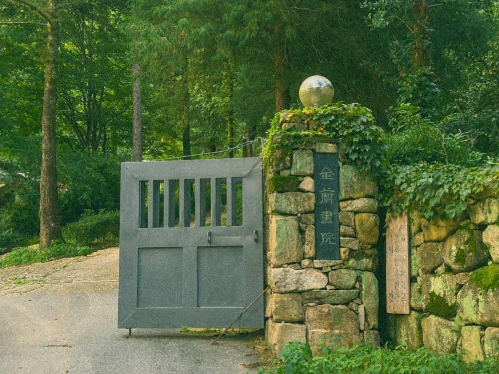 a stone gate with a metal ball on top of it