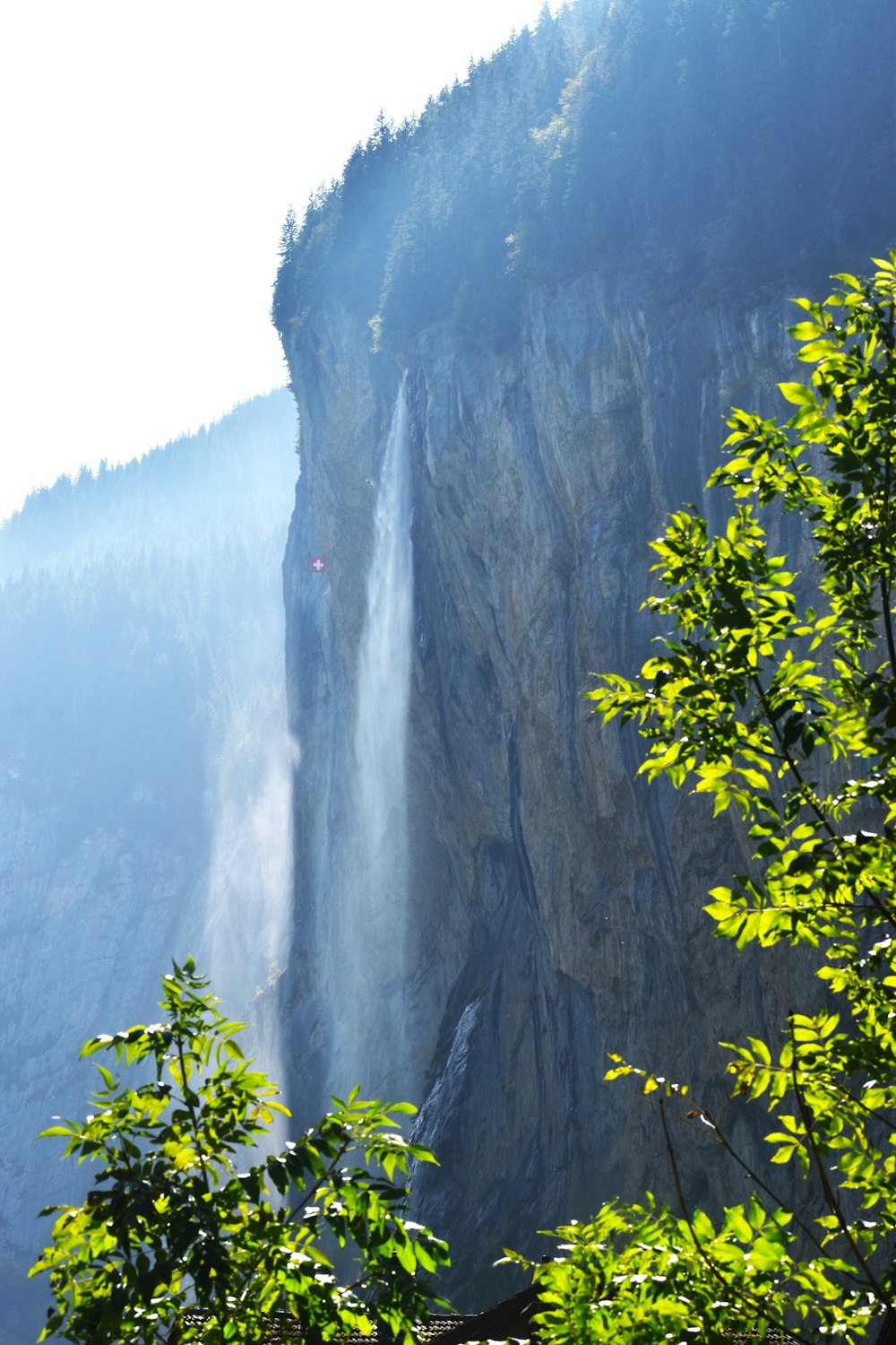 a large waterfall with a forest in the background