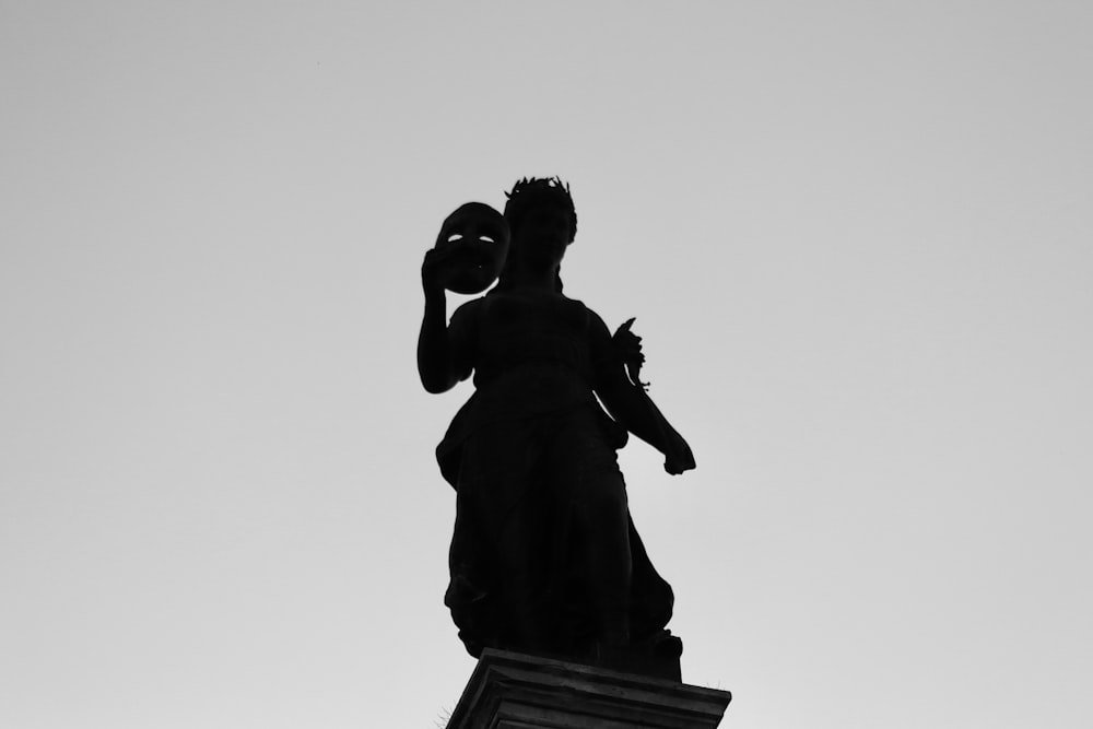 a black and white photo of a statue of a woman holding a baby