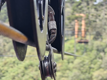 Close-up of a 3D printed rescue pulley hanging from a rope in a mountain rescue scenario