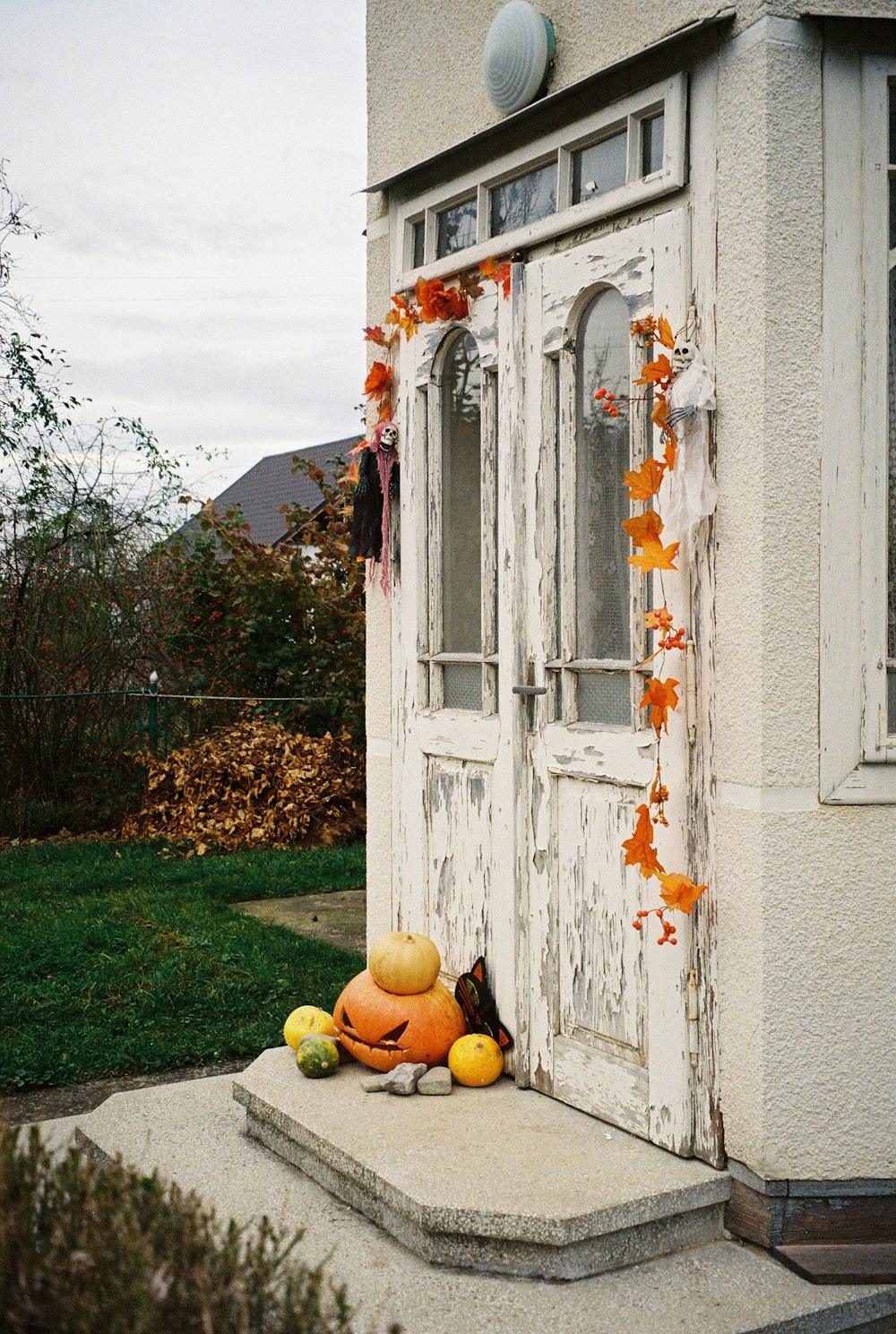 pumpkins and gourds sit outside of an old door