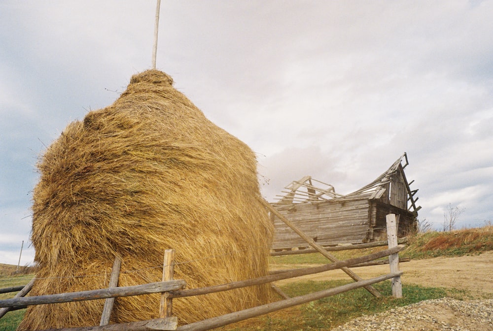 a large hay bale sitting next to a wooden fence