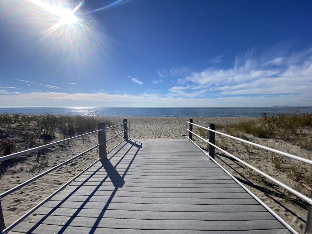 a boardwalk leading to the beach on a sunny day