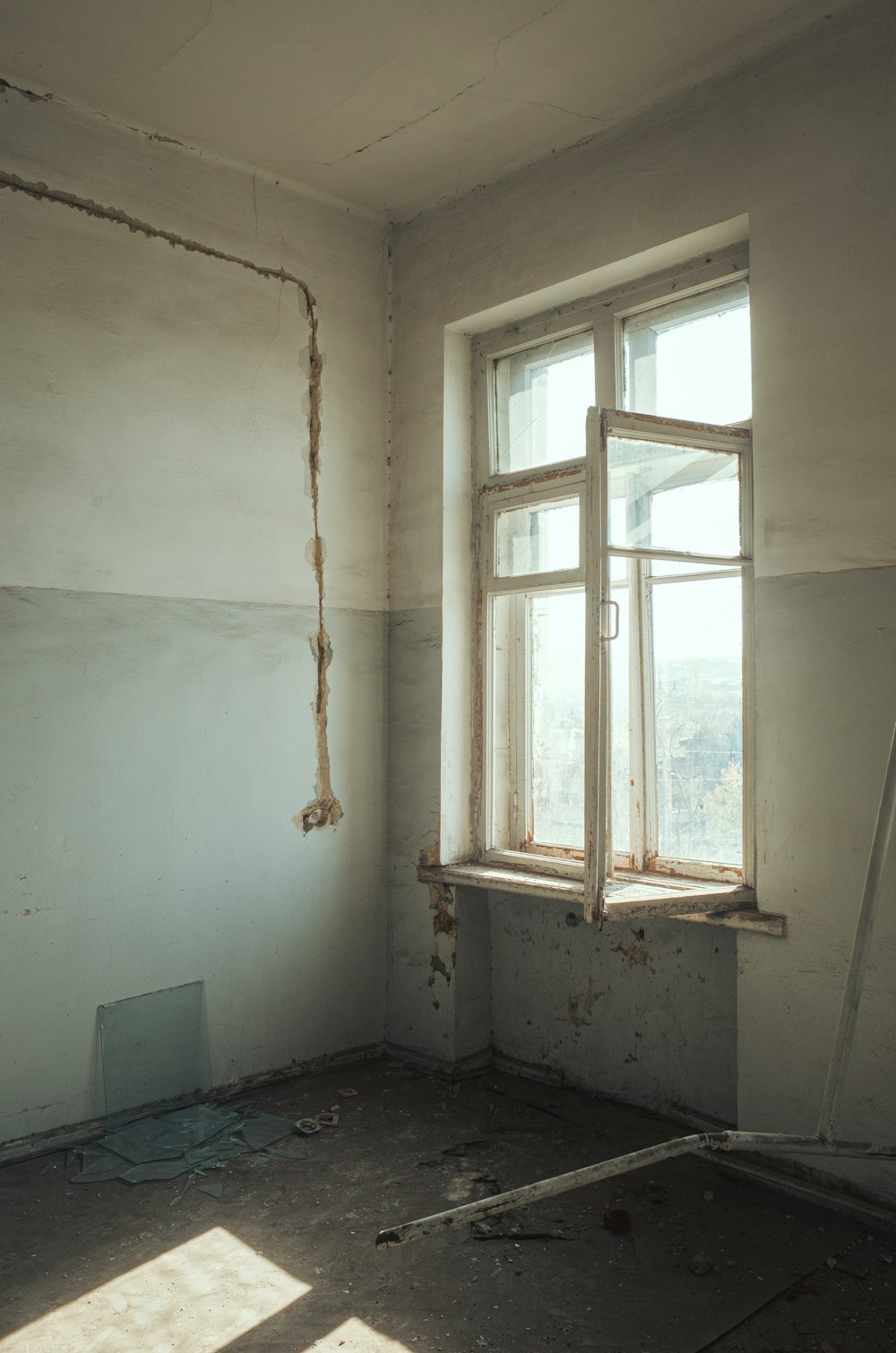 an empty room with a window and a ladder