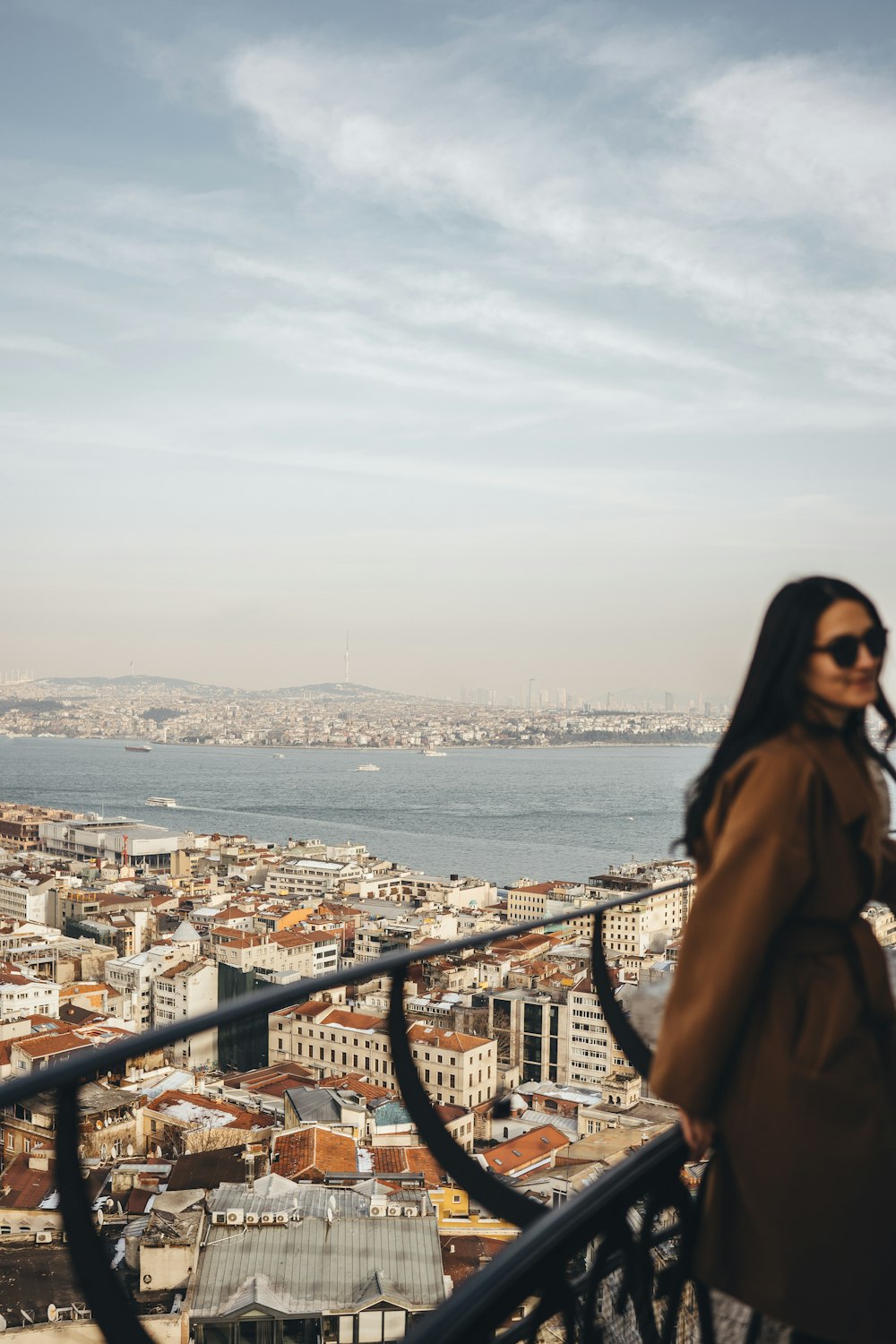 a woman standing on a balcony overlooking a city