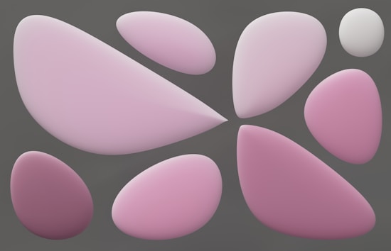 A collection of smooth, rounded shapes in various shades of pink and white, set against a muted gray background. The shapes vary in size and have a soft, matte texture, resembling abstract forms or pebbles.