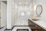 Elegant bathroom featuring marble finishes and a rainfall shower.