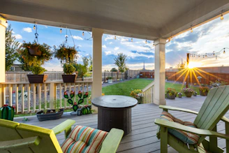 A cozy backyard scene featuring a solid wood grill table surrounded by metal geometric ornaments.