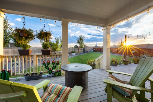 A cozy patio area with a fire pit surrounded by flowering plants.