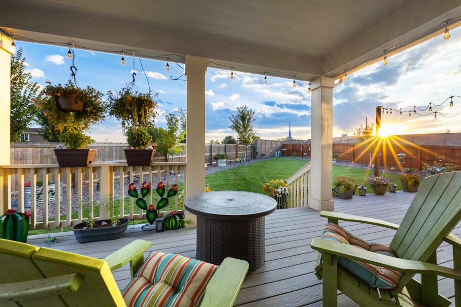 A cozy backyard scene featuring a solid wood outdoor dining set with waterproof seat pads, softly lit by solar-powered path lights at dusk.