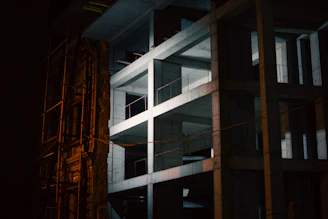 Evening shot of a partially completed building illuminated by construction lights, highlighting structural precision