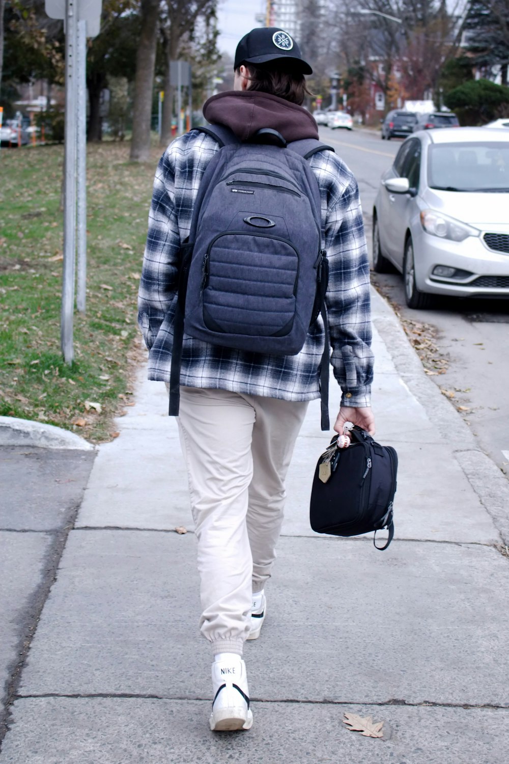a man walking down a sidewalk with a backpack