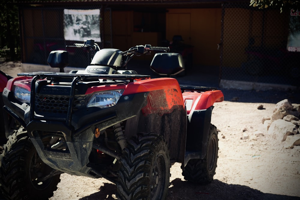 a red four wheeler parked in front of a building