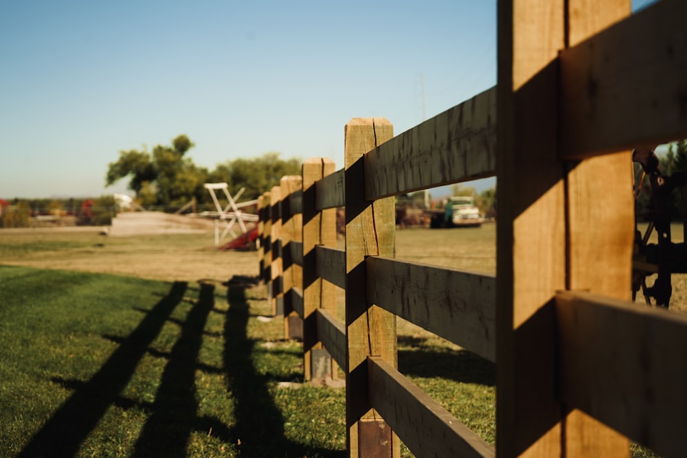 a close up of a wooden fence with a plane in the background