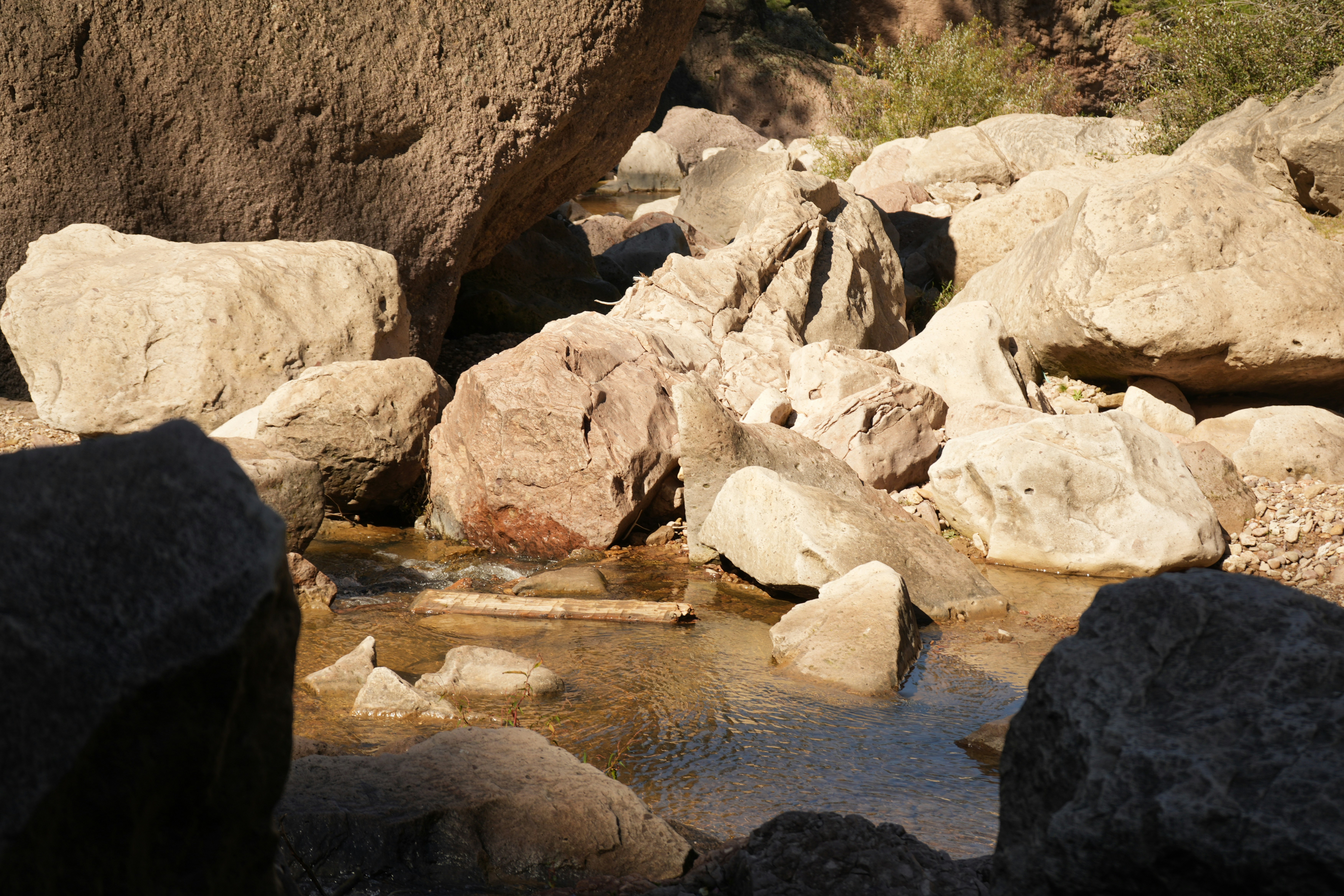 un ruscello d'acqua circondato da grandi rocce