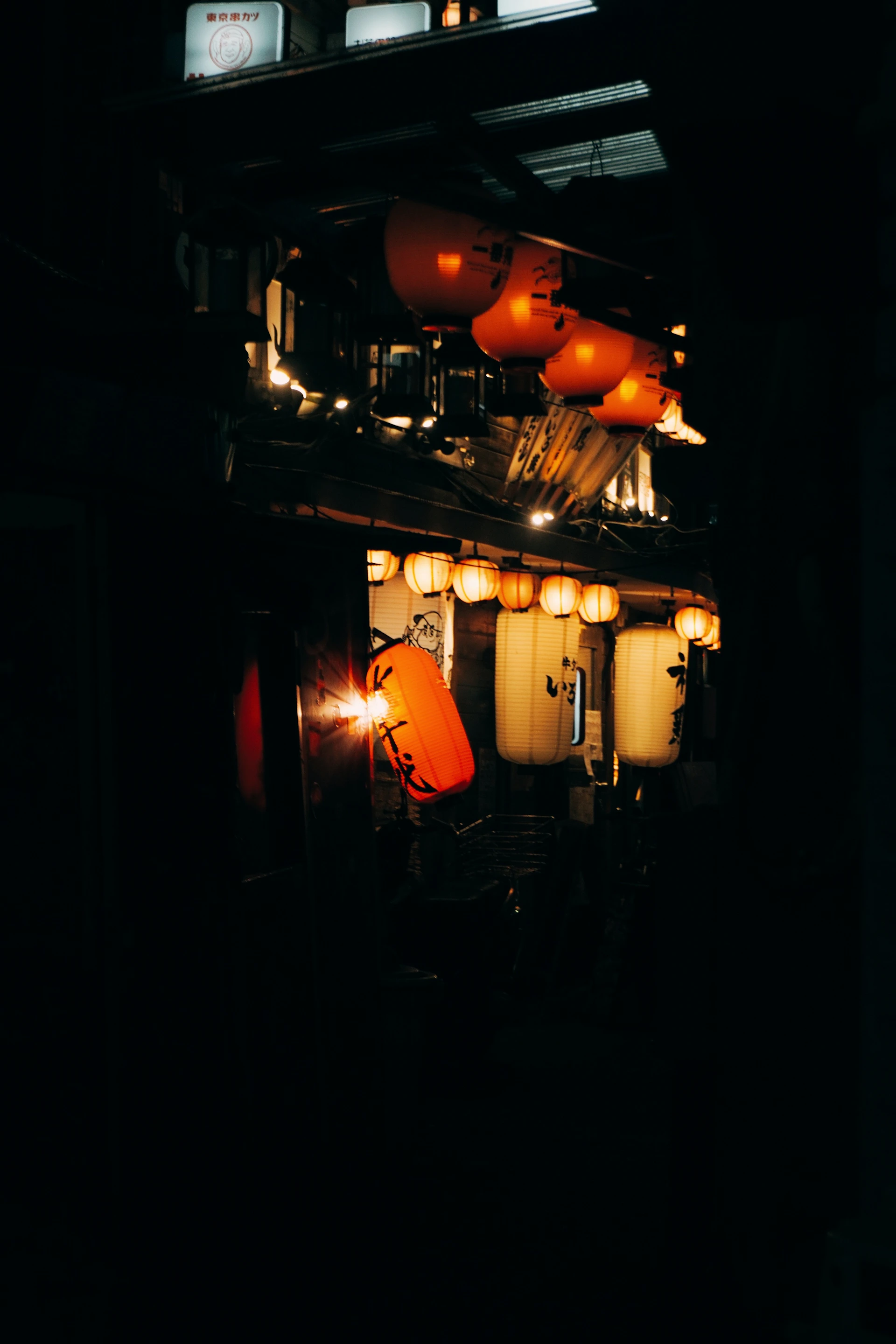 A softly lit street in Jiufen at dusk, glowing with warm lanterns and mist weaving through narrow alleys.