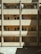 A multi-story building facade with a beige exterior features three levels of windows and balconies. Curtains are drawn across several windows, while air conditioning units are mounted above. The design includes exposed beams and subtle architectural details, with a play of light and shadow across the building's surface.