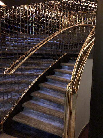 Elegant glass staircase with golden accents in a high-end residential setting.