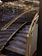 A staircase with luxurious features including glass and gold handrails, complemented by reflective wall panels that create a rich, elegant ambiance.