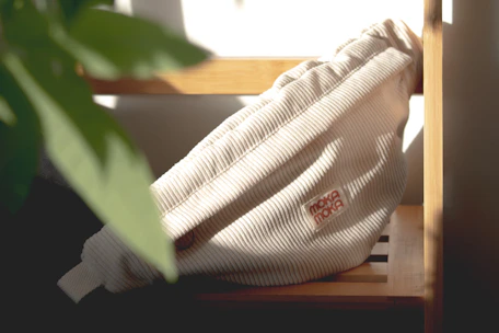 Chunky handmade bag resting on a textured wooden surface with soft natural light.