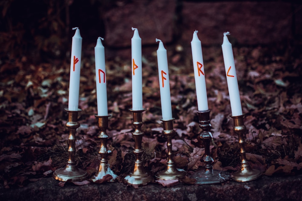 a group of candles sitting on top of a pile of leaves