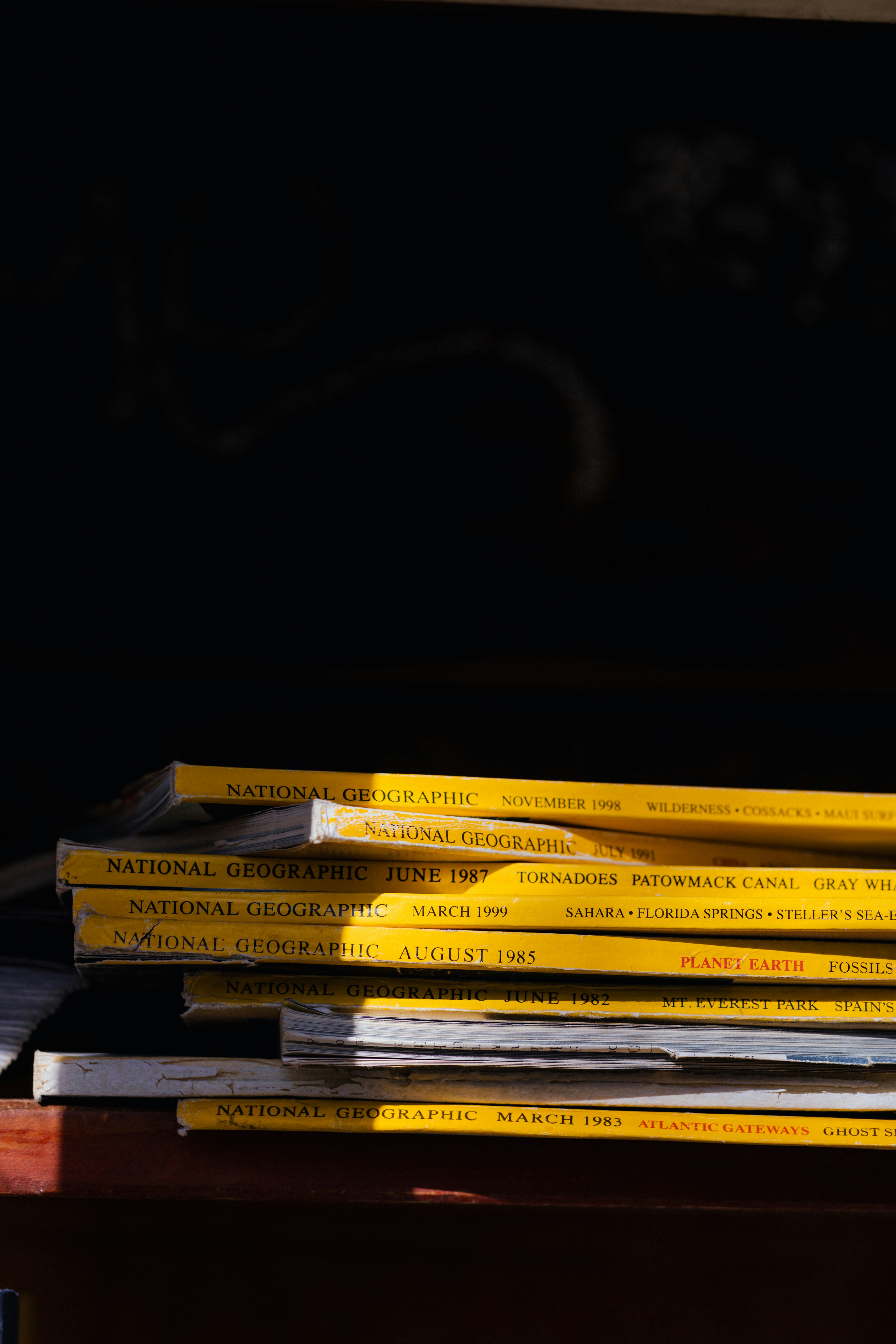 a stack of books sitting on top of a wooden table