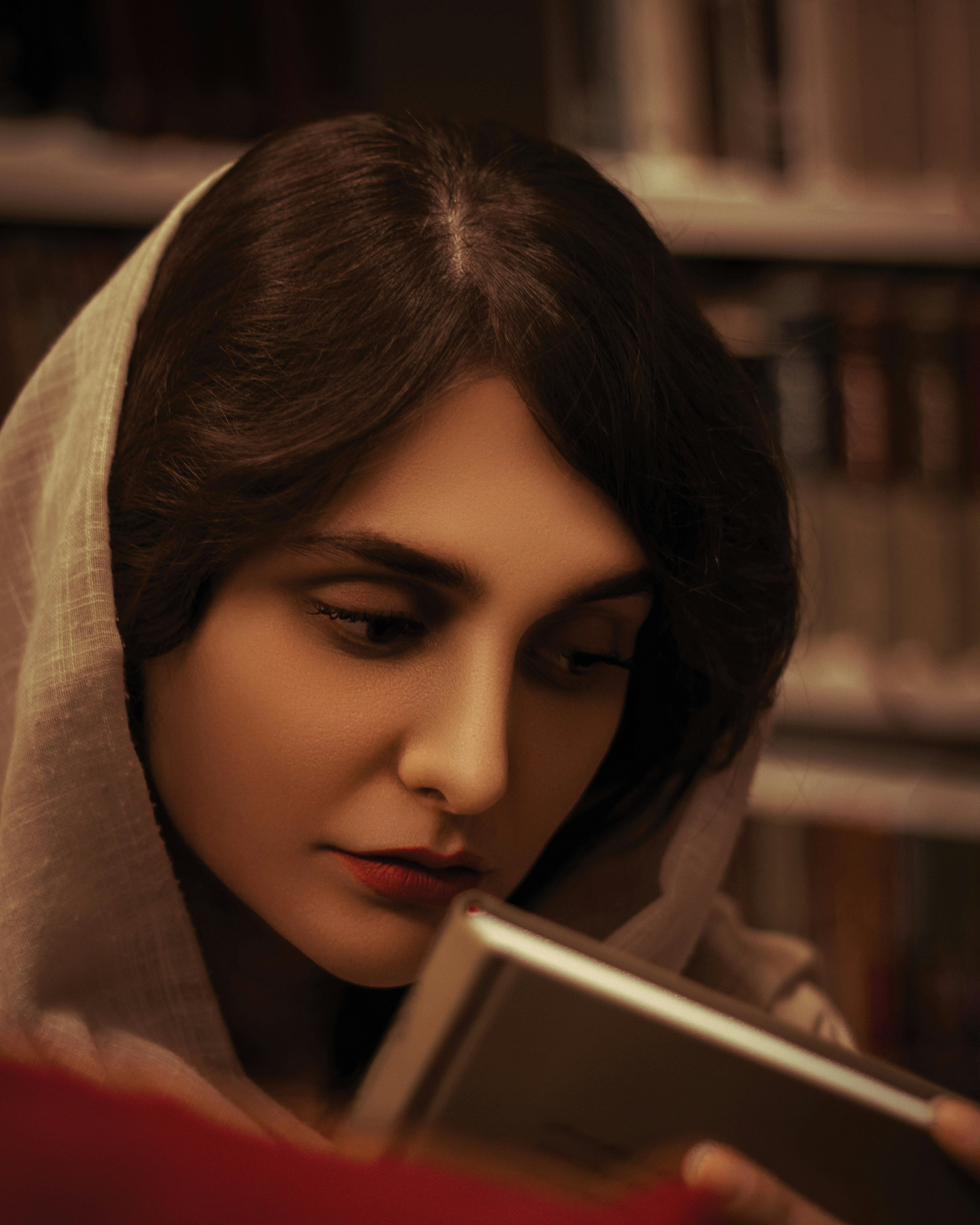 una donna che legge un libro in una biblioteca