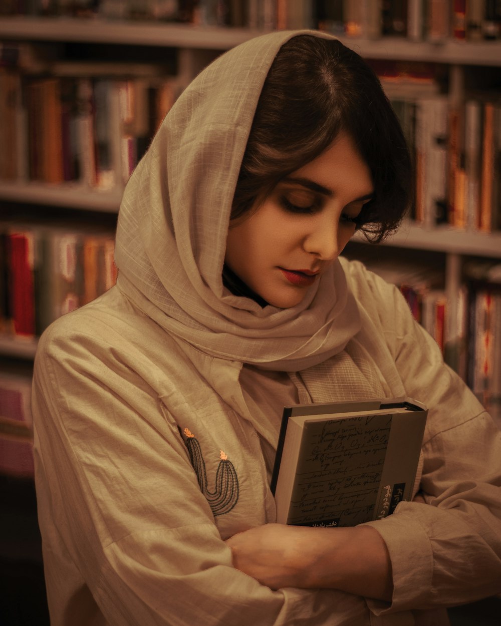 a woman in a hijab is reading a book