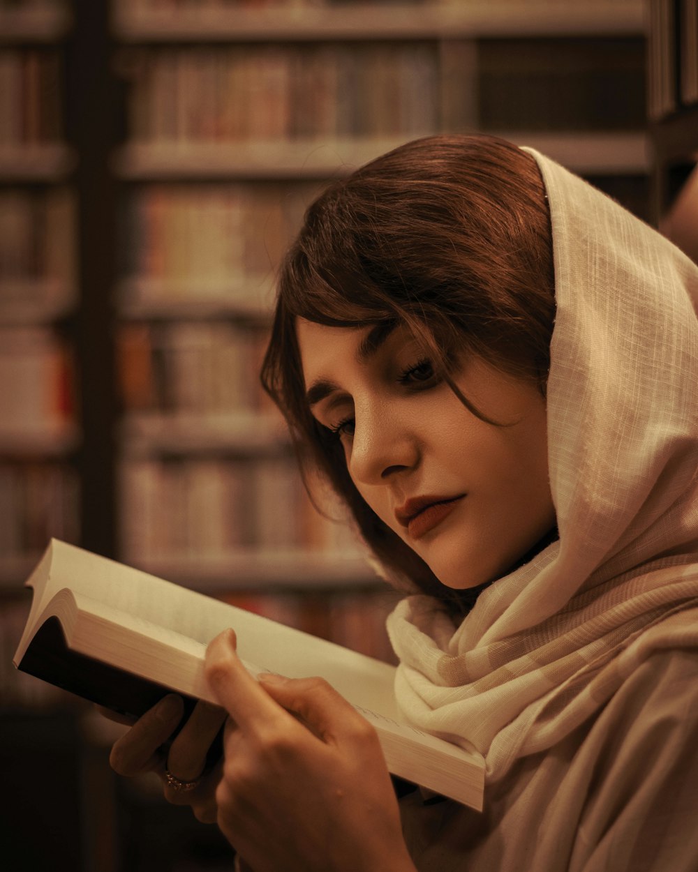 a woman reading a book in a library