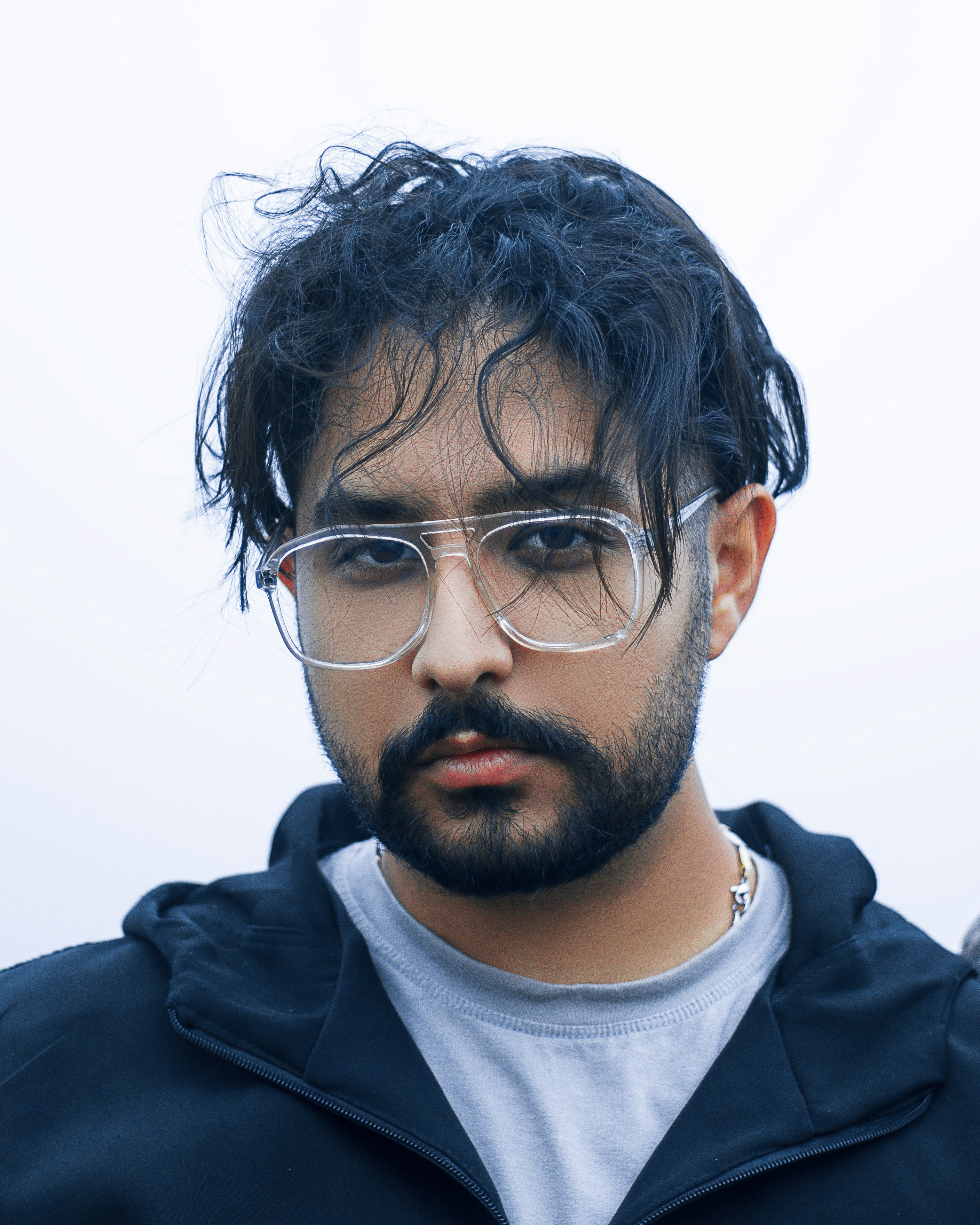 un uomo con la barba e gli occhiali che guarda la telecamera